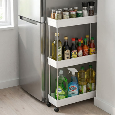 petite desserte cuisine blanche 3 étages à côté du réfrigérateur maximise l'espace vertical